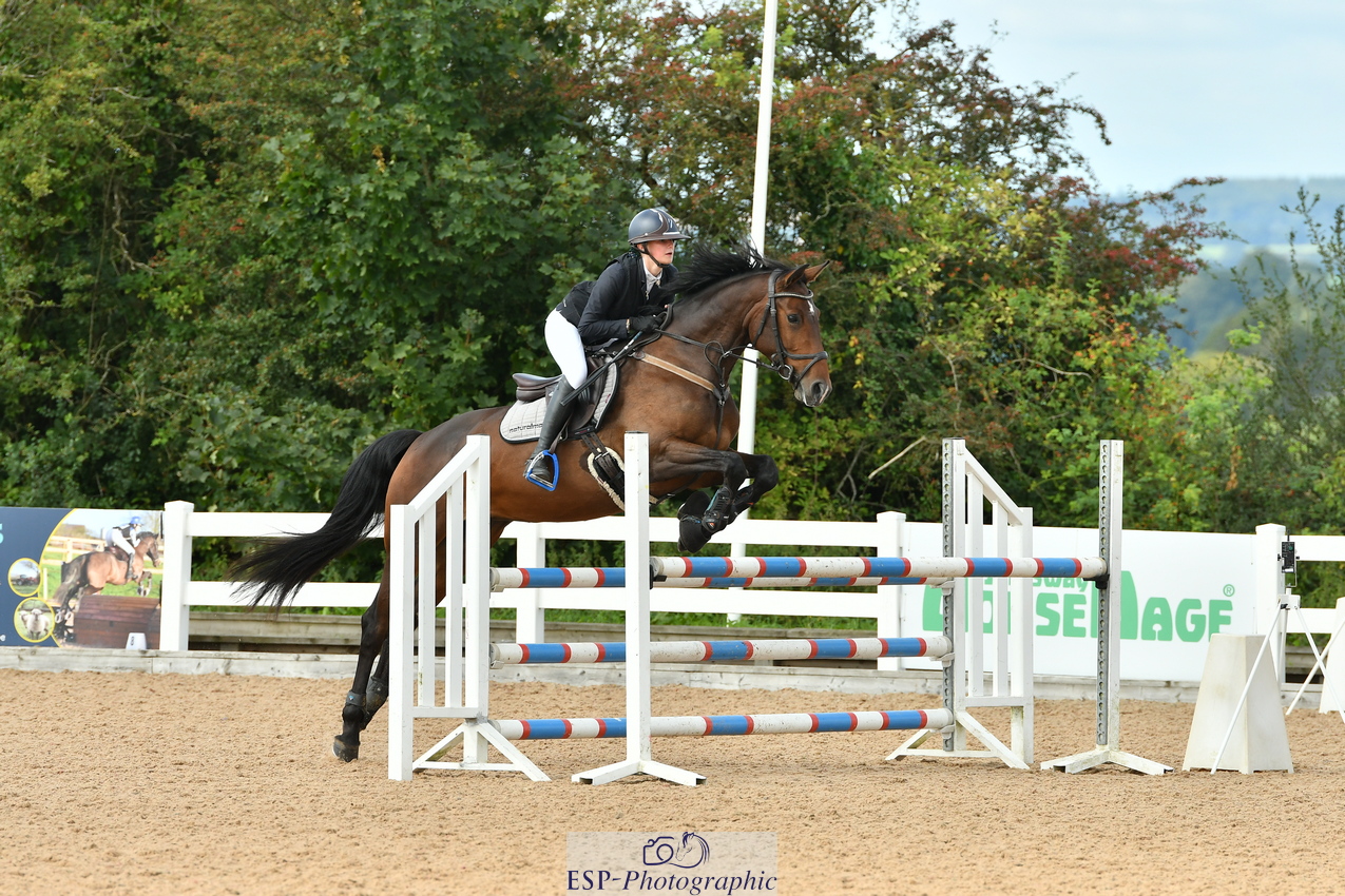 Young girl show jumping a horse